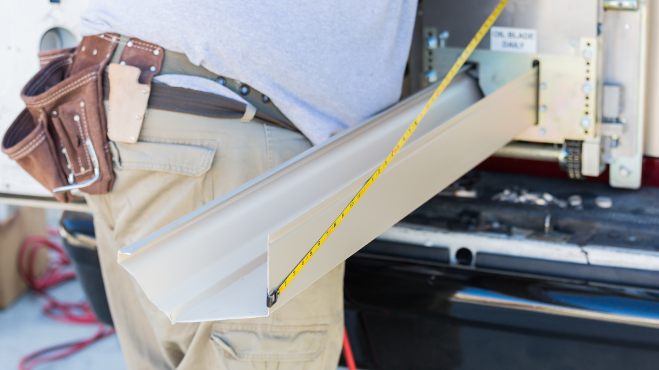 Worker Measuring Rain Gutter